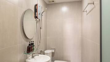 Un baño moderno con inodoro, lavamanos y ducha.