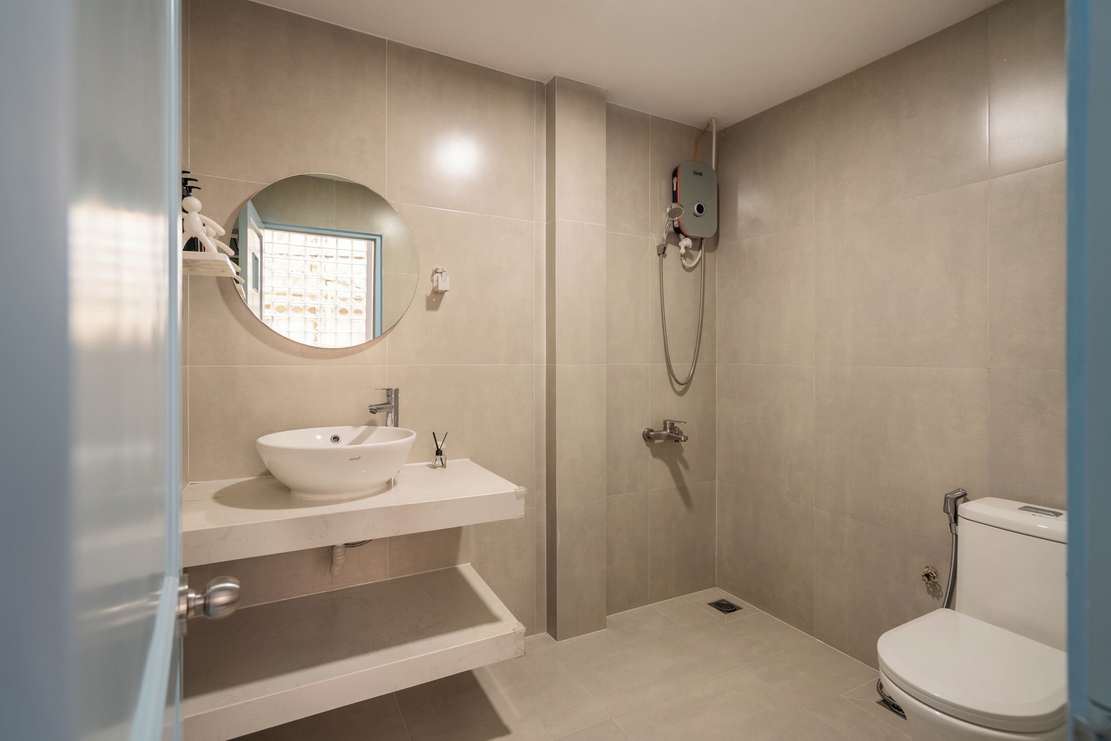 A modern bathroom with a white sink, mirror, and toilet.