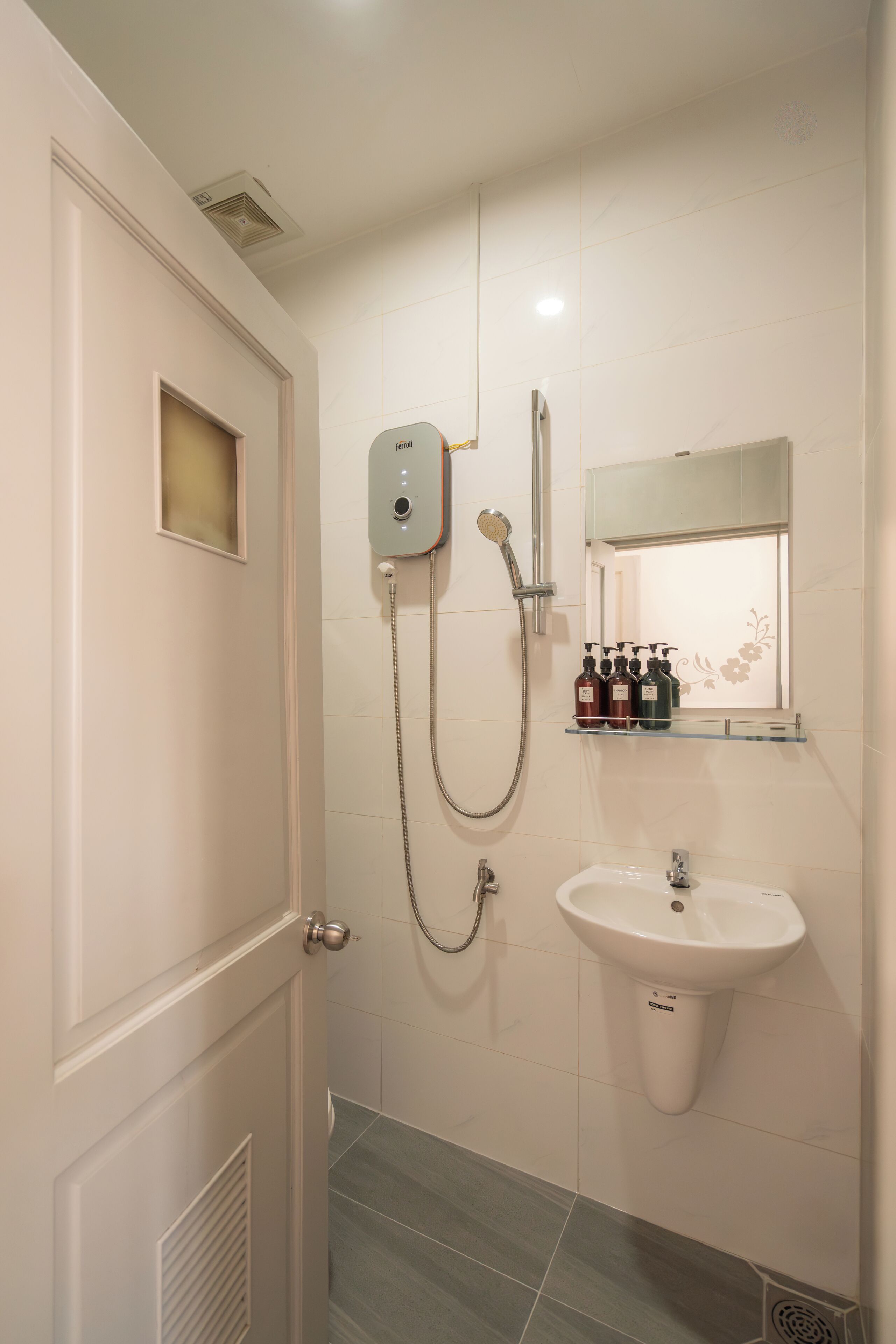 A bathroom with a shower, a sink, and a mirror.