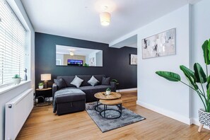 A modern living room with a sofa, a coffee table, and a TV.