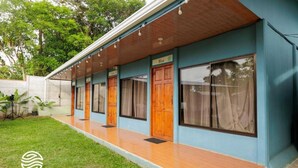 A hotel with a covered outdoor area, wooden doors, and a blue exterior. - Hotel Rio Celeste Dreams (Bijagua)