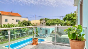 A balcony with a swimming pool, potted plants, and a view of a neighboring building. - Aunt Celeste's House I, a Home in Madeira (Ponta do Sol)