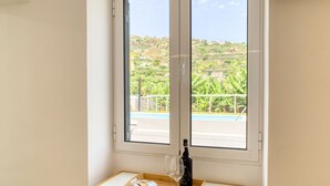 A room with a large window overlooking a pool and greenery. - Aunt Celeste's House III, a Home in Madeira (Ponta do Sol)