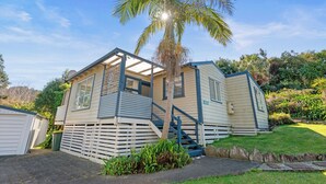 A mobile home with a porch, a staircase, and a palm tree in the background.