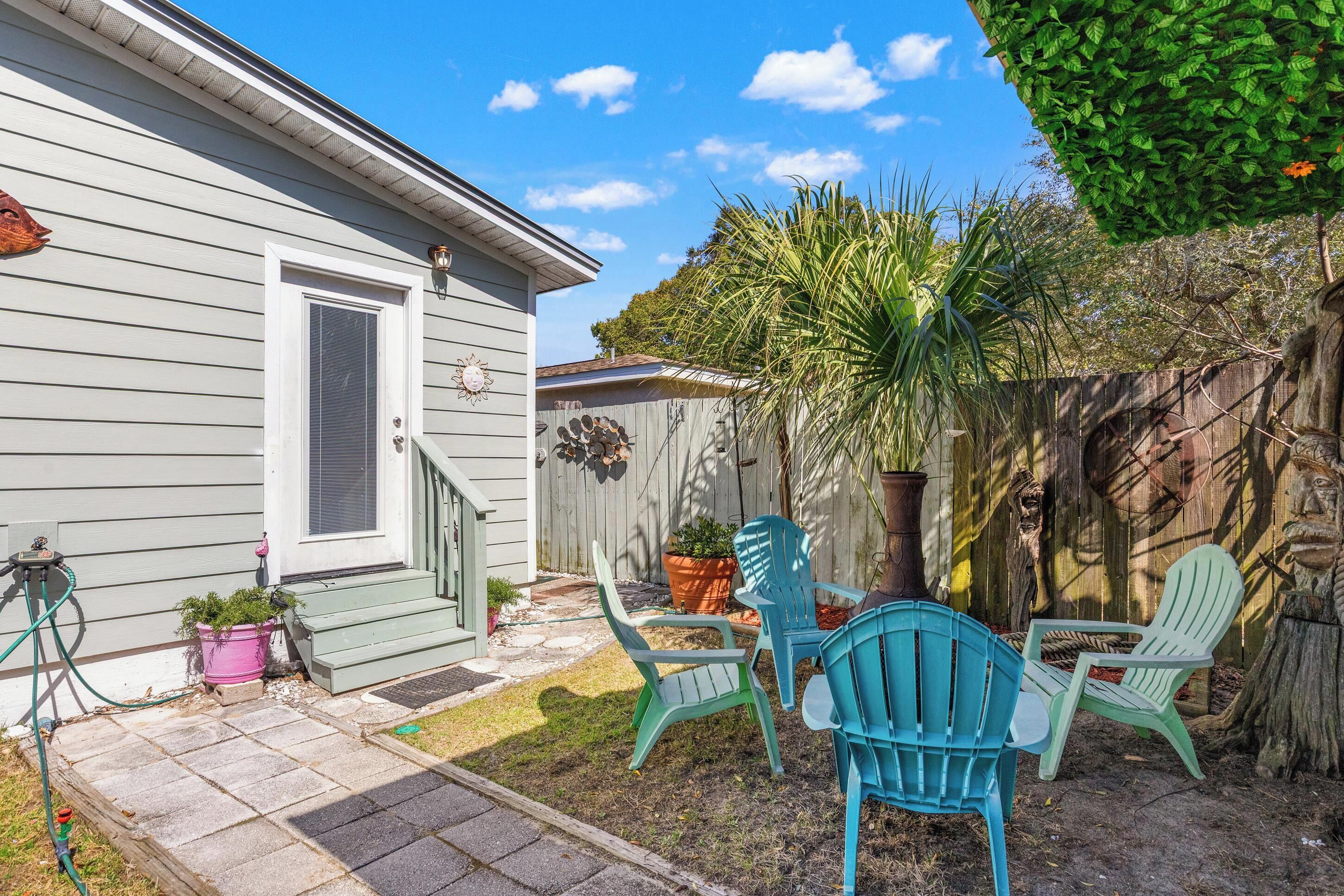 A house with a porch, outdoor seating, and a garden.