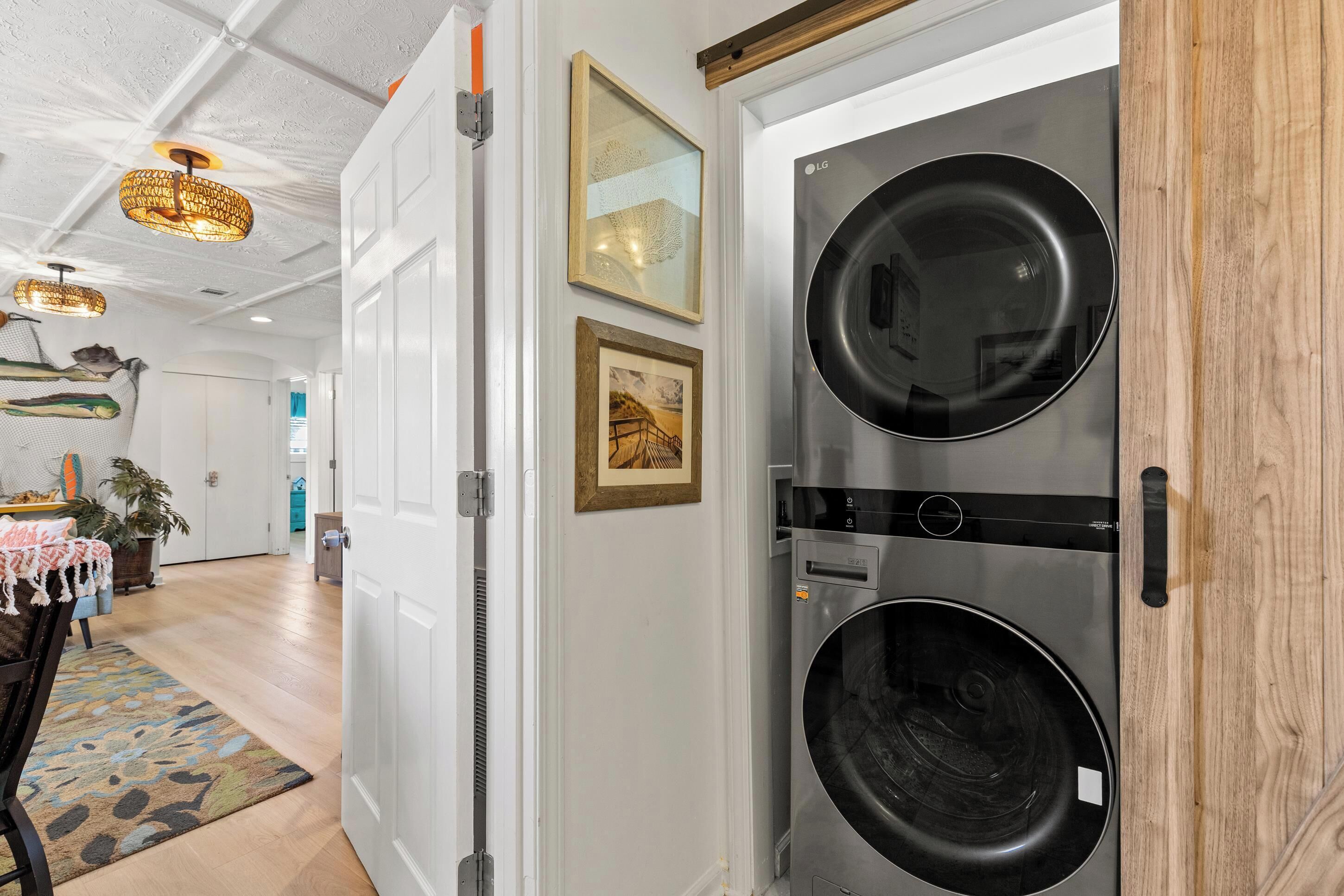 A laundry room with a large industrial washer and dryer, a door with a handle, and a wall-mounted light fixture.