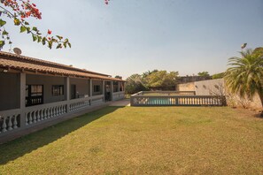 A courtyard with a building featuring a tiled roof and a balcony with a balustrade. - Ch Cara Silveira Lazer Completo a 5 min do Centro (Araçoiaba da Serra)
