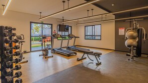 A gym with treadmills, dumbbells, and weight machines. - Nex One Nhambiquaras (São Paulo)
