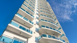 A high-rise hotel with multiple balconies and a modern architectural design.