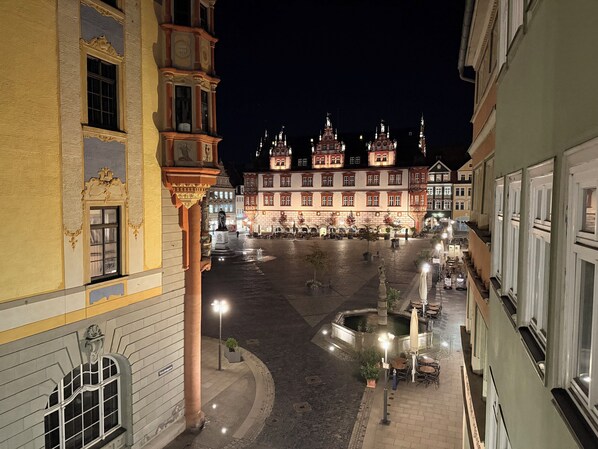 A historic building with ornate architecture, a courtyard, and outdoor seating areas.