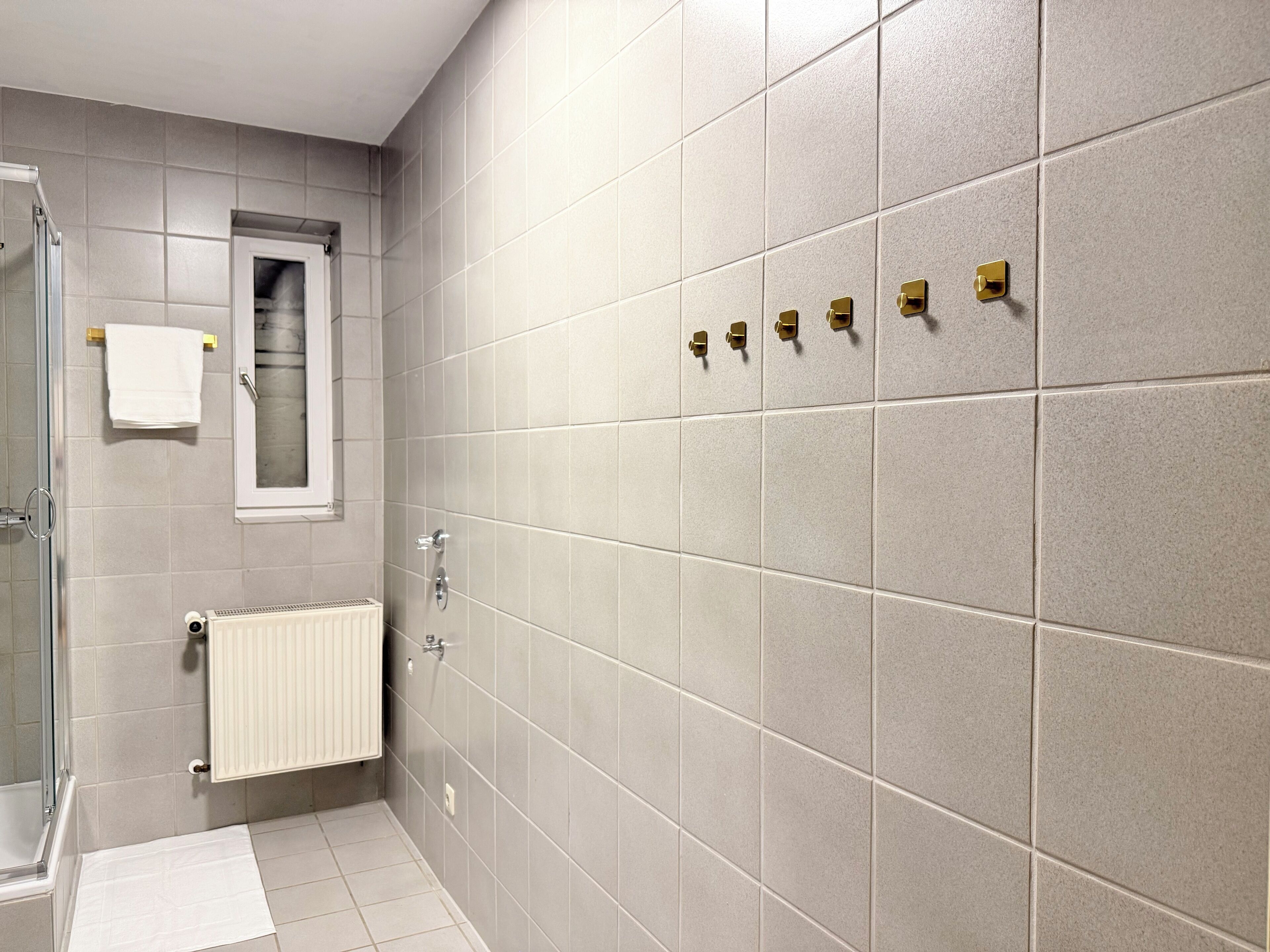 A bathroom with a shower, a toilet, and a towel rack.