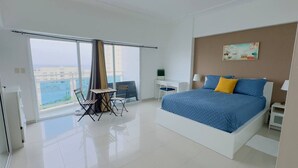 A modern bedroom with a large bed, a desk, and a chair.