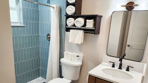 Une salle de bain comprenant des toilettes, un lavabo et un espace douche.