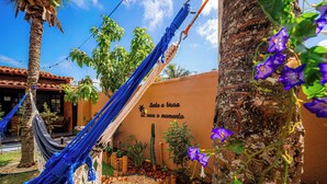 A hammock, a cactus, and a wall with a message. - Brisas do Oceano Lofts (Buzios)