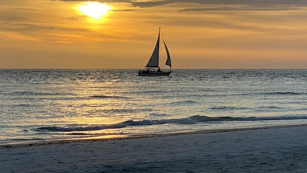 A sailboat on calm waters during sunset. - Newly renovated  2 bedroom condo on siesta key beach…steps to private beach. (Siesta Key)