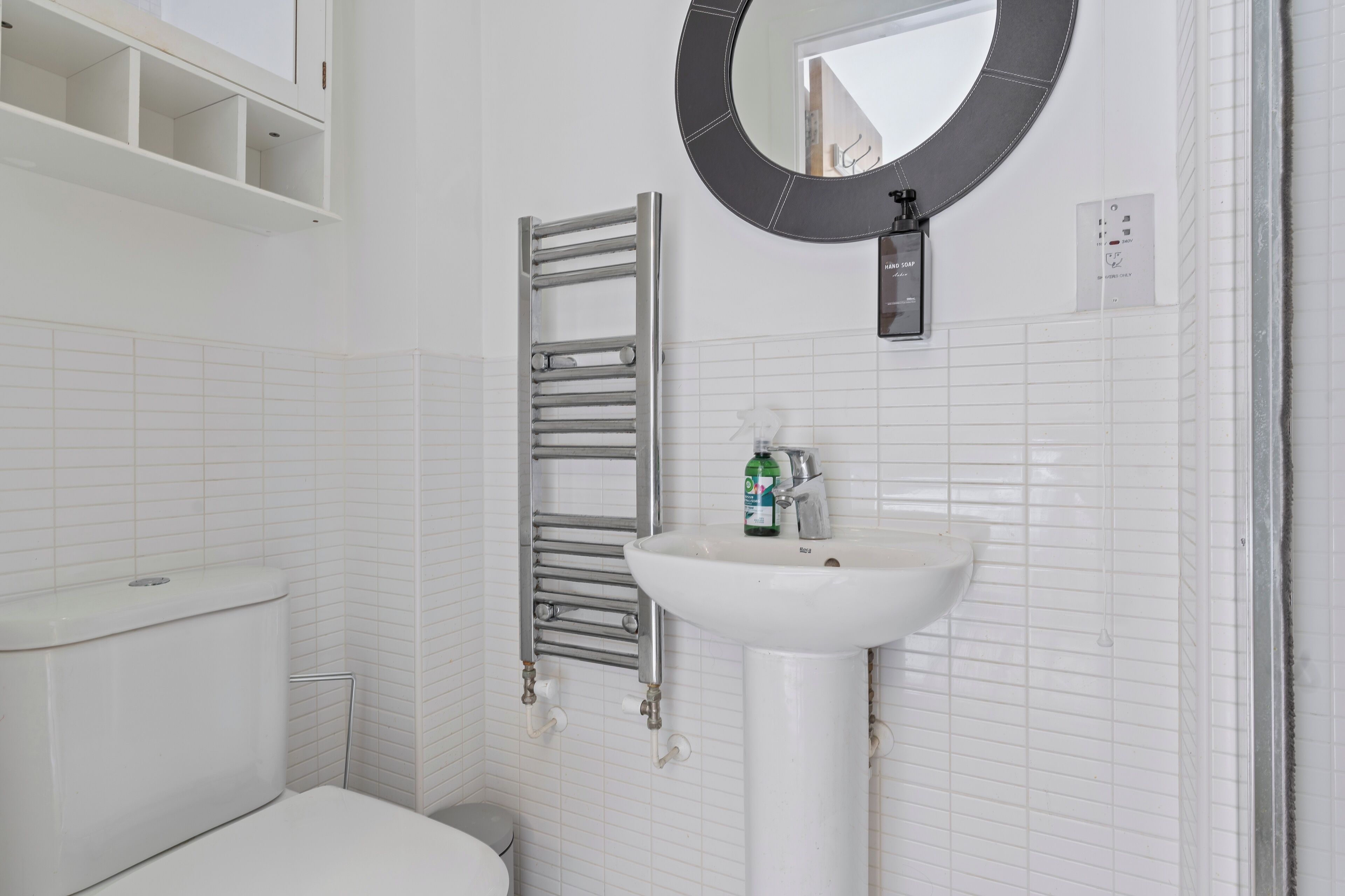 Ein Badezimmer mit Toilette, Waschbecken, Handtuchhalter und Spiegel.