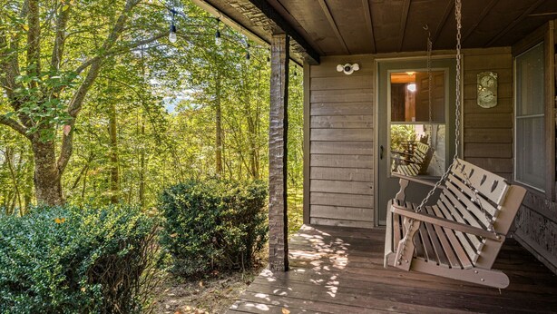 A wooden porch with a swing chair, surrounded by trees and a wooden fence. - Almost Heaven – Porch Swing Mountain Getaway (Franklin)