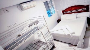 A hotel room with a bunk bed, a single bed, a window with a view, and a marble floor. - Airbhouse Prívate Rooms & Triana (Seville)