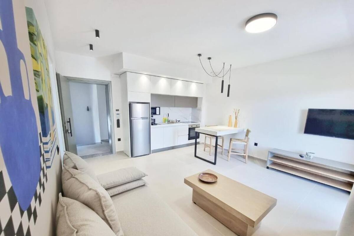 A modern living room with a sofa, a coffee table, and a dining area with a table and chairs.