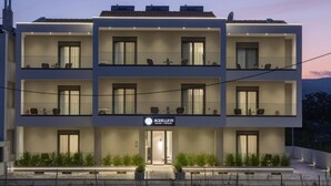 A modern multi-story hotel with balconies, a sign reading "ACHILLION," and a well-lit entrance. - Achillion Suites (Lefkada)