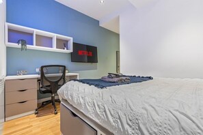 Tabla de planchar con plancha, acceso a internet y ropa de cama