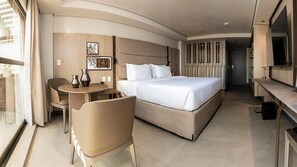 Een moderne hotelkamer met een bed, bureau, stoel en televisie.