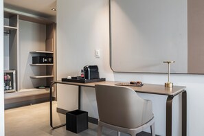 Ein moderner, minimalistischer Raum mit Schreibtisch, Stuhl und Regalen.