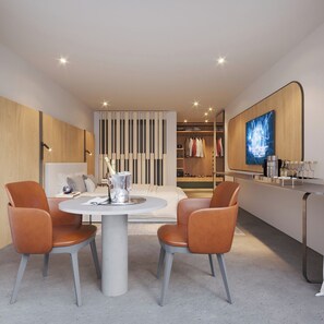 A modern living room with a dining area, a TV mounted on the wall, and a walk-in closet.