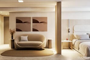 A modern hotel room with a sofa, a bed, a round rug, and two wall-mounted artworks.