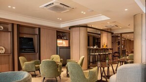 A modern lounge area with seating, a bar, and a television. - HCM - Corais De Manaira (João Pessoa)