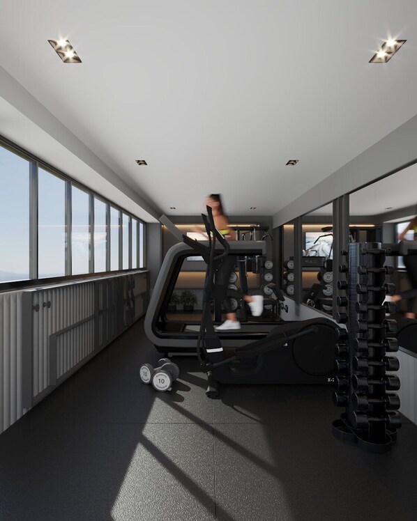 Une salle de sport moderne équipée de matériel d’exercice, dotée de grandes fenêtres et offrant une vue sur la ville.