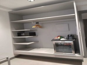 Een moderne keuken met inbouwapparatuur, een magnetron en een koffiezetapparaat.