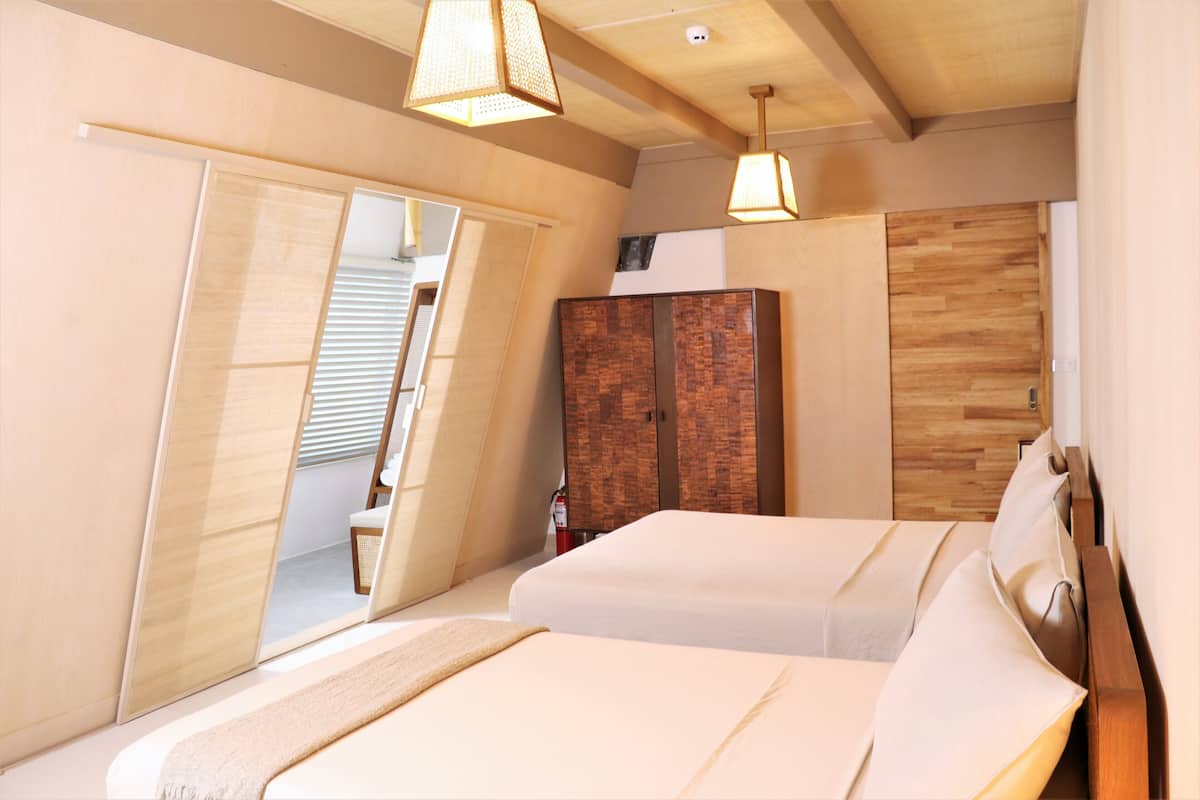 Moderni hotellihuone, jossa on suuri sänky, vaatekaappi ja kylpyhuone, joka näkyy avoimesta ovesta.