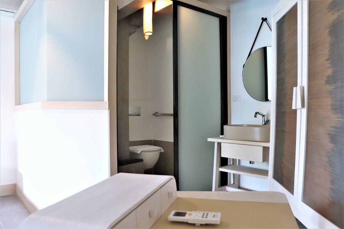 Ein modernes Badezimmer mit Toilette, Waschbecken und Spiegel.