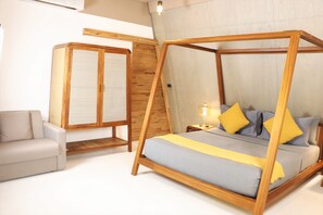 A bedroom with a four-poster bed, a sofa, and a wardrobe. - Asmara Urban Res & Lifestyle Vil Powered by Aston (Cebu City)