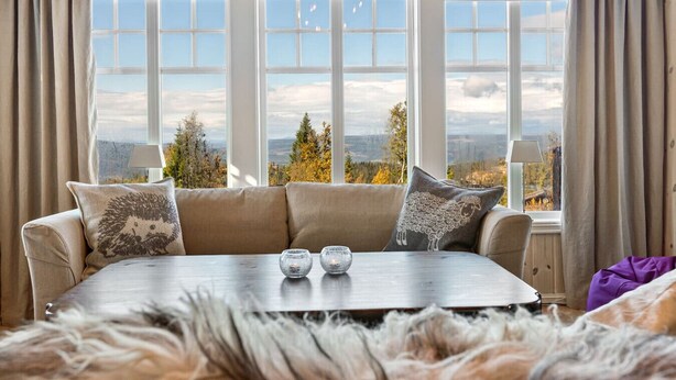 A cozy room with a sofa facing large windows offering a scenic view.