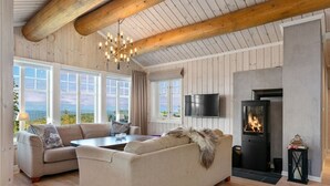 A cozy living room with a large sofa, a coffee table, and a fireplace.