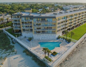 Un hôtel à plusieurs étages doté d’une piscine, de balcons et offrant une vue sur la plage.
