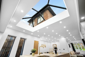 Ein modernes Interieur mit Oberlicht, Küchenbereich und Sitzgelegenheit.