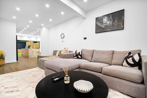 A modern living room with a sectional sofa, a black coffee table, and a remote control.