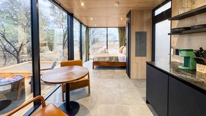 Una cucina moderna con zona pranzo, ampie finestre e vista sull'esterno.