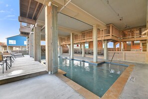 A pool area with wooden deck seating and a clear view of the pool.
