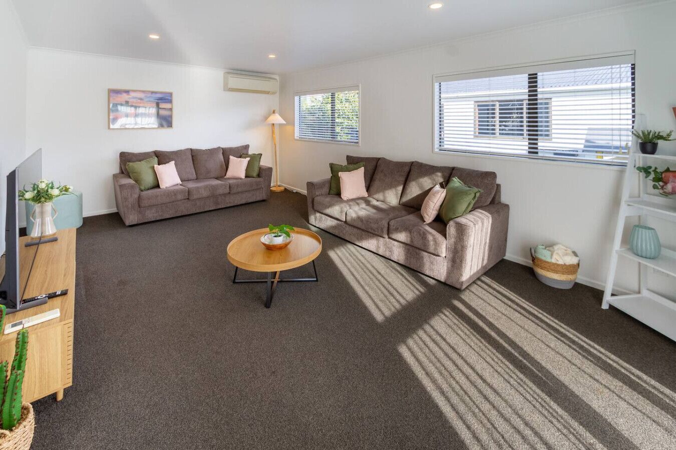 A living room with two sofas, a coffee table, a TV, and a bookshelf.