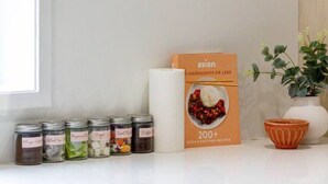A kitchen counter with jars of spices, a cookbook, and a potted plant. - Urban Utopia 2 Bedroom Retreat (Christchurch)