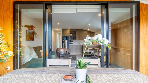 Una sala de estar moderna con un sofá, una mesa de centro y una planta en maceta.