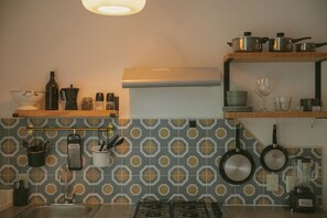 Stovetop, coffee/tea maker, cookware/dishes/utensils, dining tables