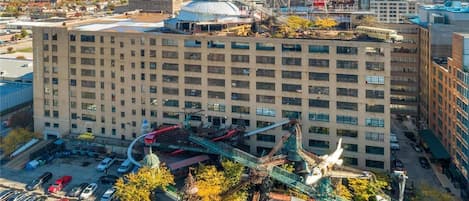 A multi-story hotel with a central courtyard, surrounded by parking and a nearby body of water.