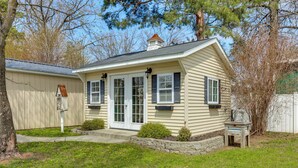 Une maison de plain-pied avec un porche à l’avant, une cheminée et un petit jardin.