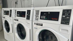 Μια σειρά από επαγγελματικά πλυντήρια σε έναν χώρο.
