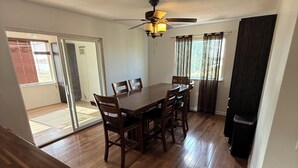 A dining area with a wooden table and chairs, a ceiling fan, and a view through a glass door. - Spacious 3-bedroom Lakeview Home Centrally Located in Quiet Neighborhood (Moses Lake)